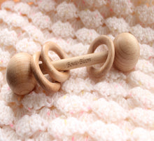 Load image into Gallery viewer, Wooden teething ring with 'Bowie Bloom' branding on a soft, textured surface.
